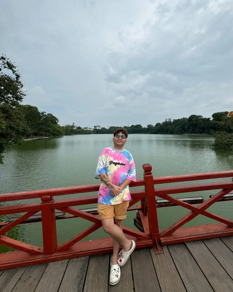 EJ in Hanoi, tie-dye shirt, on a red bridge.